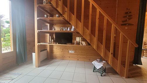 Vue de la télévision ett des livres sous les escaliers.